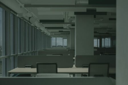 Why Corporate Flexible Work Policies Are Reducing Commercial Insurance Costs Modern empty office space with desks and chairs showing reduced occupancy