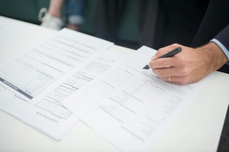 How Rising Insurance Costs Are Driving Peer-to-Peer Coverage Models Insurance policy documents and forms spread on desk with calculator