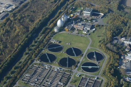 How Rising Water Scarcity Is Driving Desalination Technology Investment Growth Industrial water treatment facility with large cylindrical tanks and processing equipment