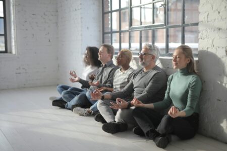 Corporate Meditation Programs Are Becoming Standard Employee Benefits Modern office meditation space with cushions and plants for employee wellness programs