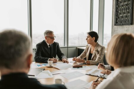 Corporate executives discussing budget allocation strategies in modern boardroom setting
