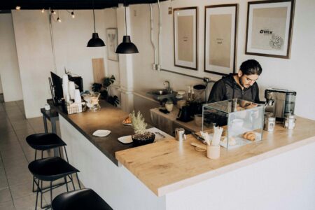 Modern coffee shop interior with minimal seating and focus on counter service area