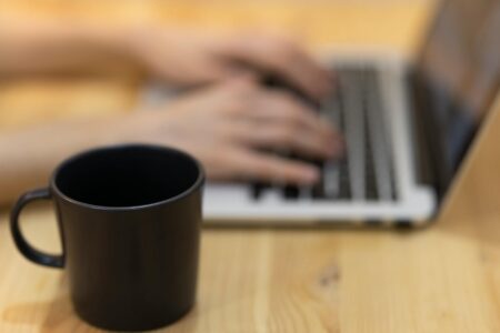 How Freelancer Health Insurance Cooperatives Are Reducing Independent Contractor Costs Freelancer working on laptop with coffee cup, representing independent contractor lifestyle