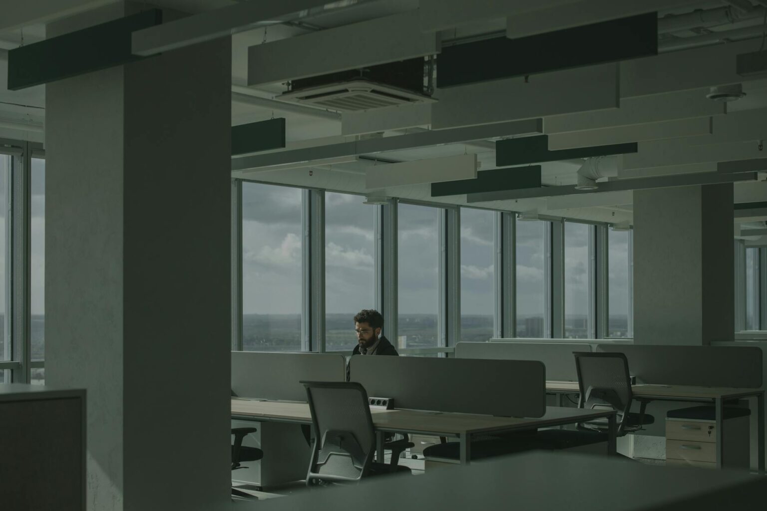 Why Corporate Layoffs Are Concentrated in Customer Service Departments Empty office cubicles representing corporate layoffs in customer service departments