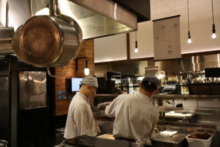 Professional commercial kitchen with stainless steel equipment and prep stations