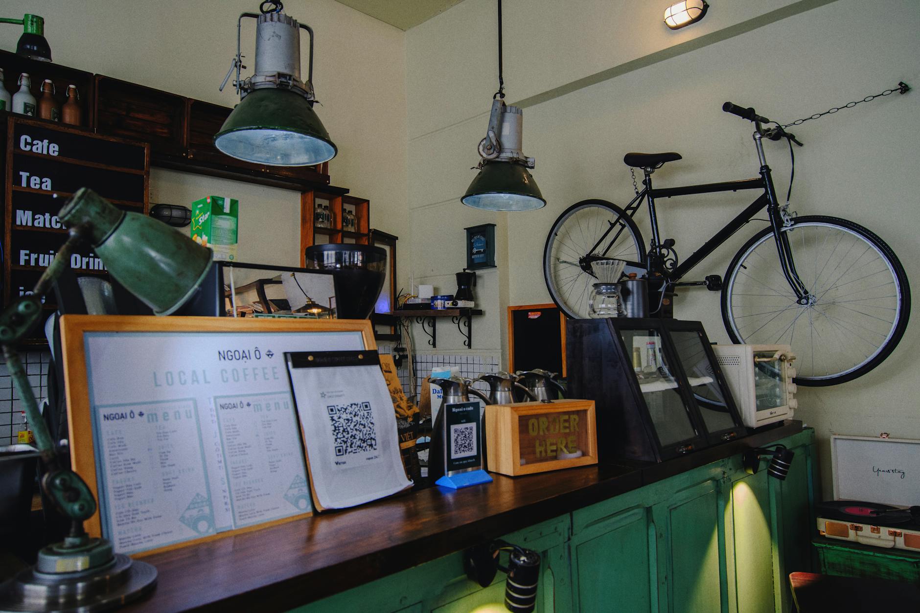 Modern coffee shop interior with customers at tables and barista working behind counter