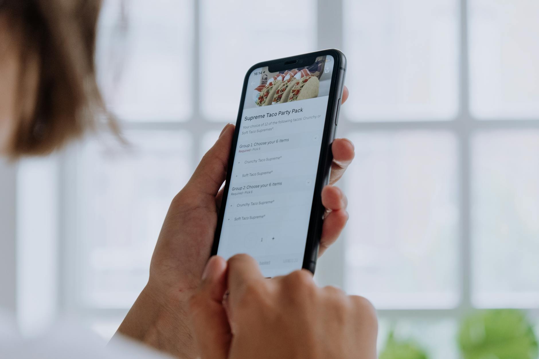 Person using smartphone to place mobile order at coffee shop counter