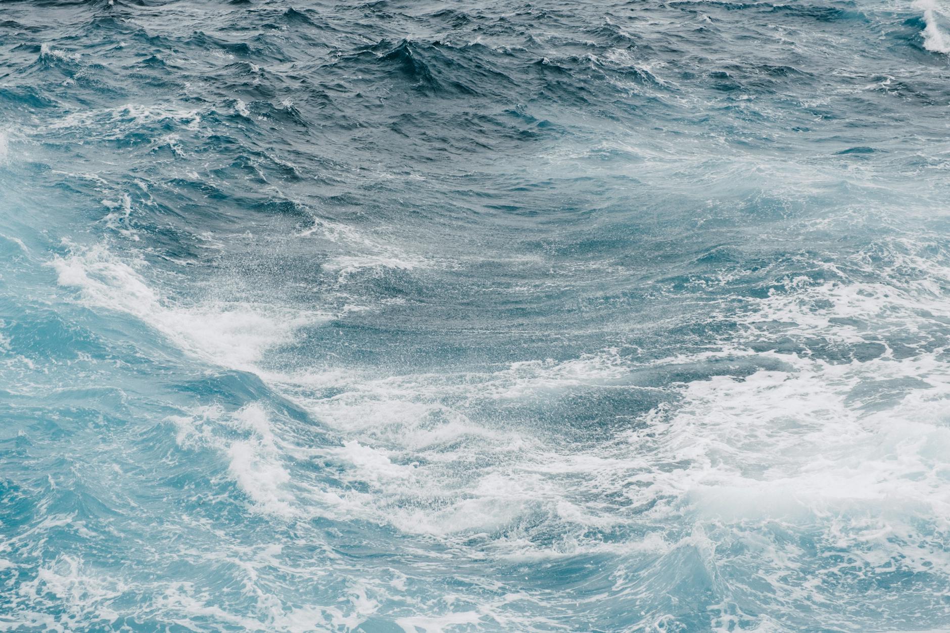 Aerial view of ocean coastline with waves meeting the shore, representing seawater source for desalination