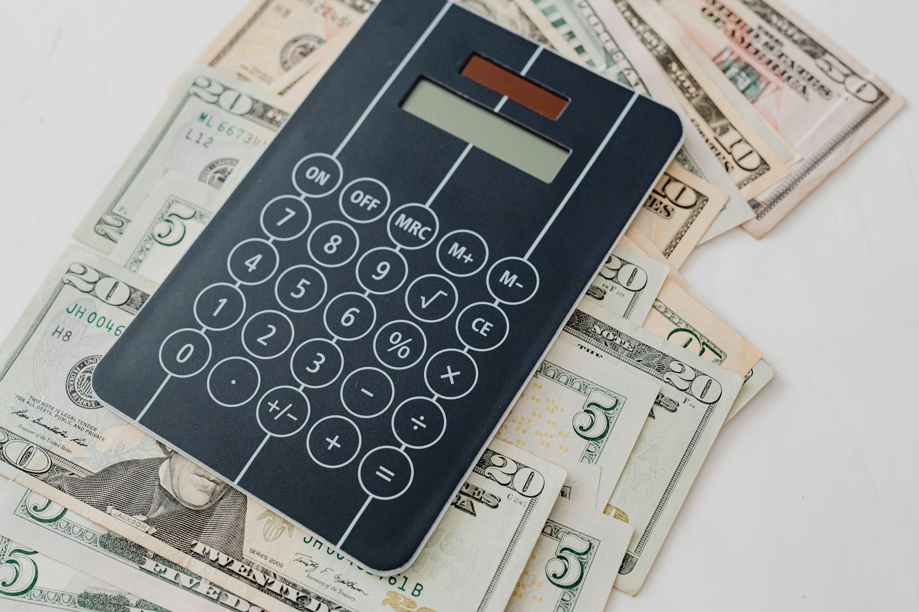 Calculator and financial documents with money, representing dividend income calculations and returns