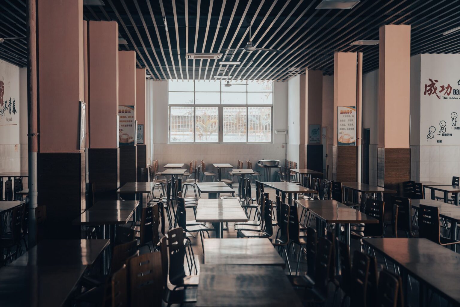 Corporate Cafeterias Are Quietly Replacing Free Perks With Paid Models Employees eating lunch in a modern corporate cafeteria with self-serve food stations