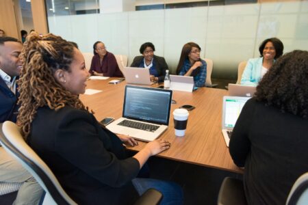 Corporate Wellness Budgets Are Quietly Shifting Toward Financial Coaching Employees in a corporate meeting discussing workplace benefits and wellness programs