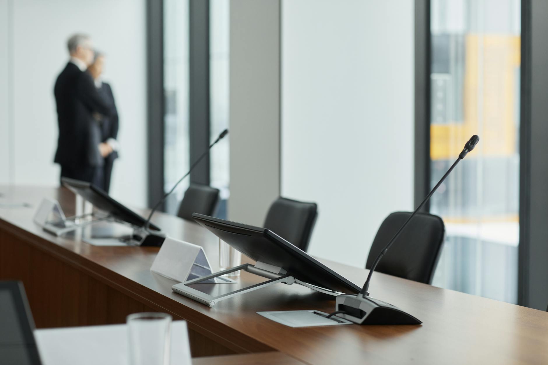 Empty corporate boardroom with chairs around a long conference table, representing executive investment decisions
