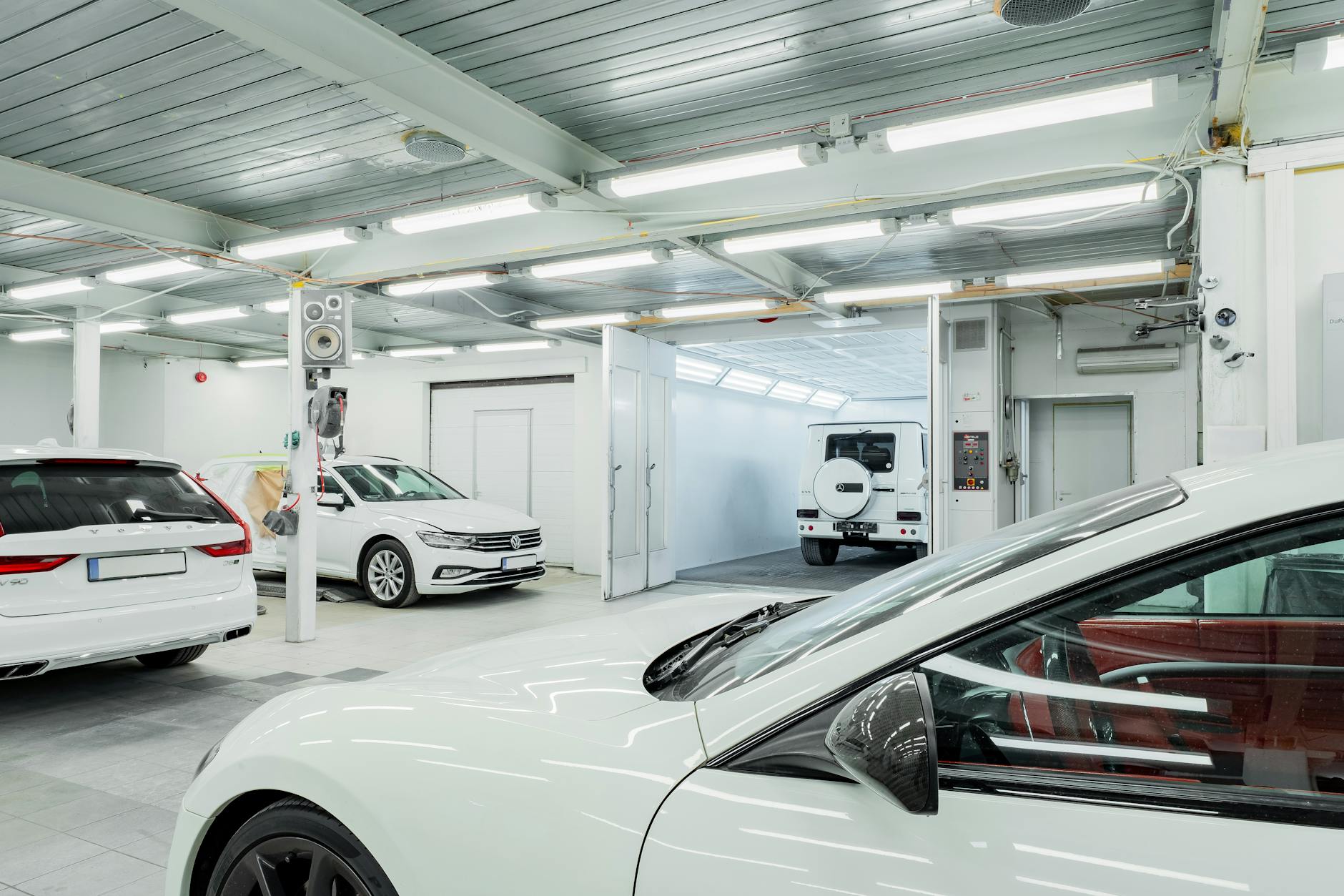 Modern automotive service bay with hydraulic lifts and electrical equipment