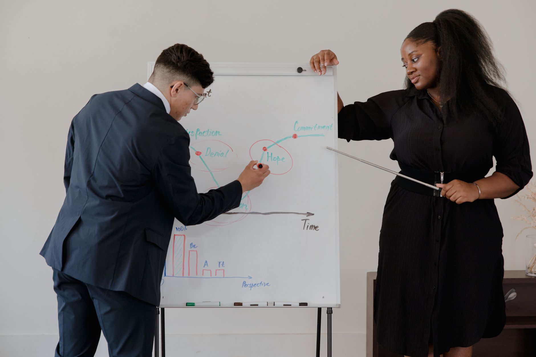 Senior professional guiding a younger colleague during a workplace discussion