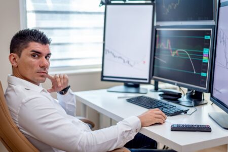 Multiple trading screens displaying stock market data and options pricing charts