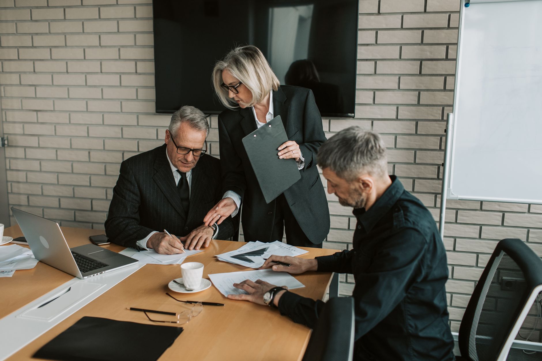 Business professionals discussing strategy around a conference table in a corporate boardroom