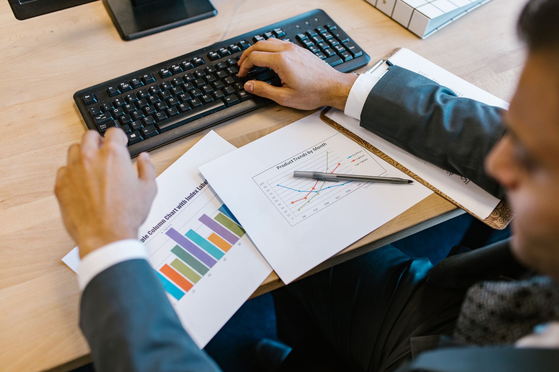 Financial charts and graphs displayed on a desk monitor in a trading environment