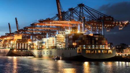 Large cargo ship docked at an industrial port, representing global commodity trade logistics
