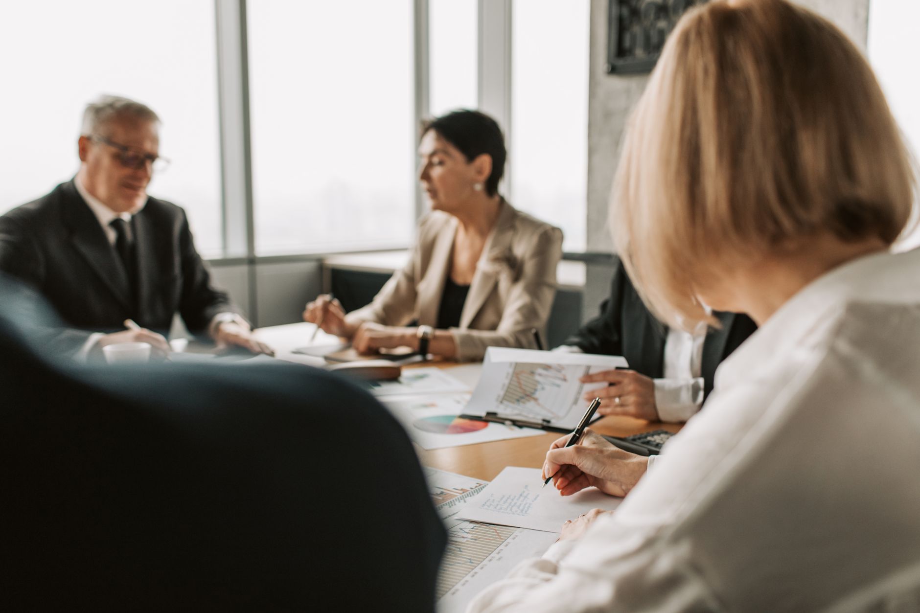 Business executives in a boardroom reviewing financial documents during a meeting