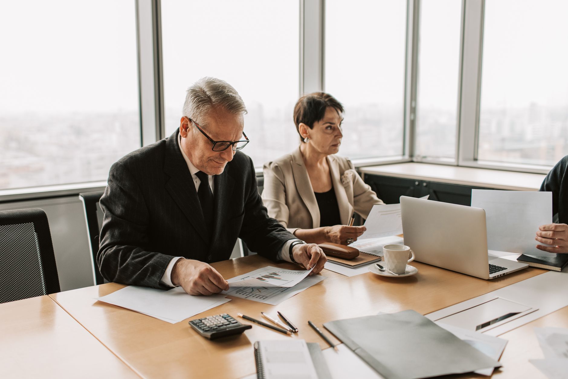 Corporate executive reviewing financial documents in a formal meeting setting