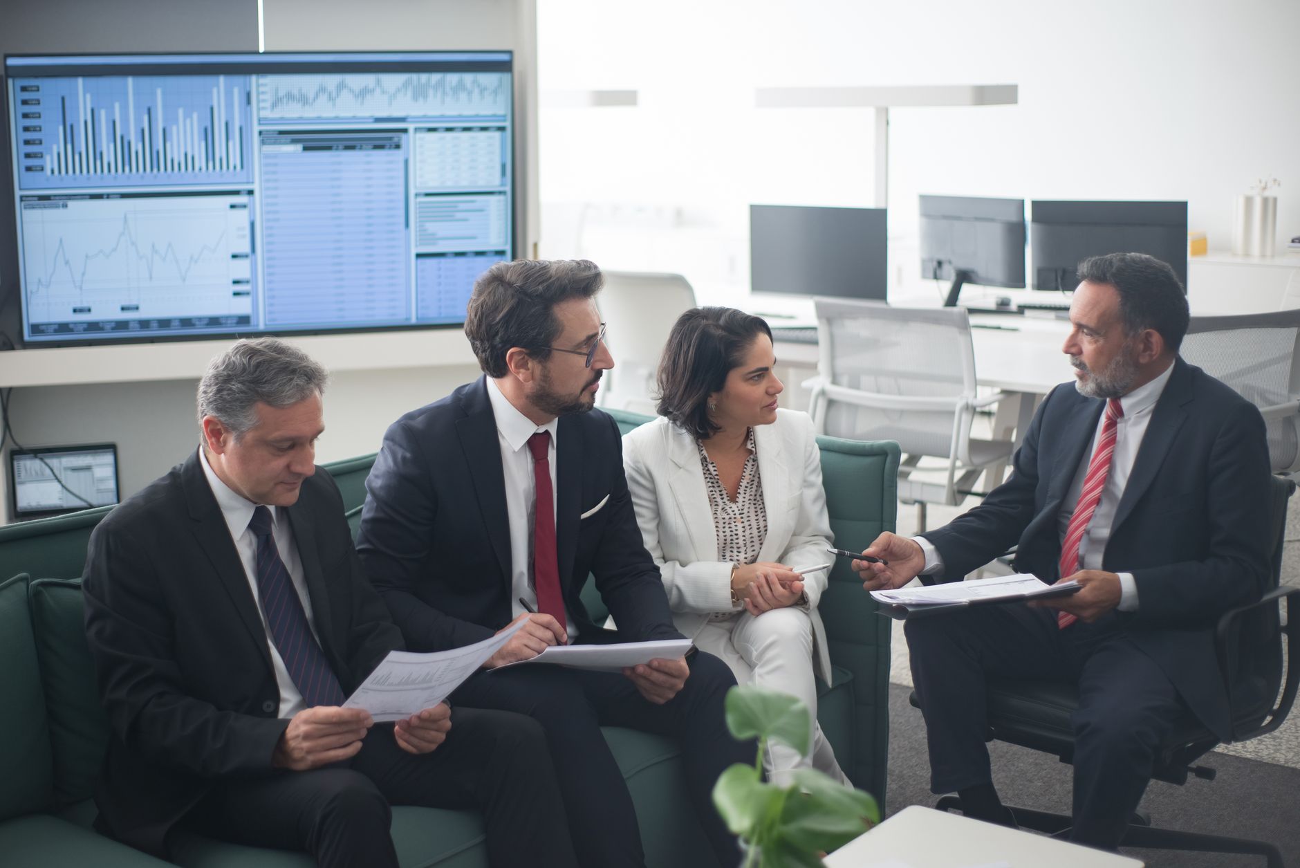Finance professionals reviewing documents in a bank meeting room
