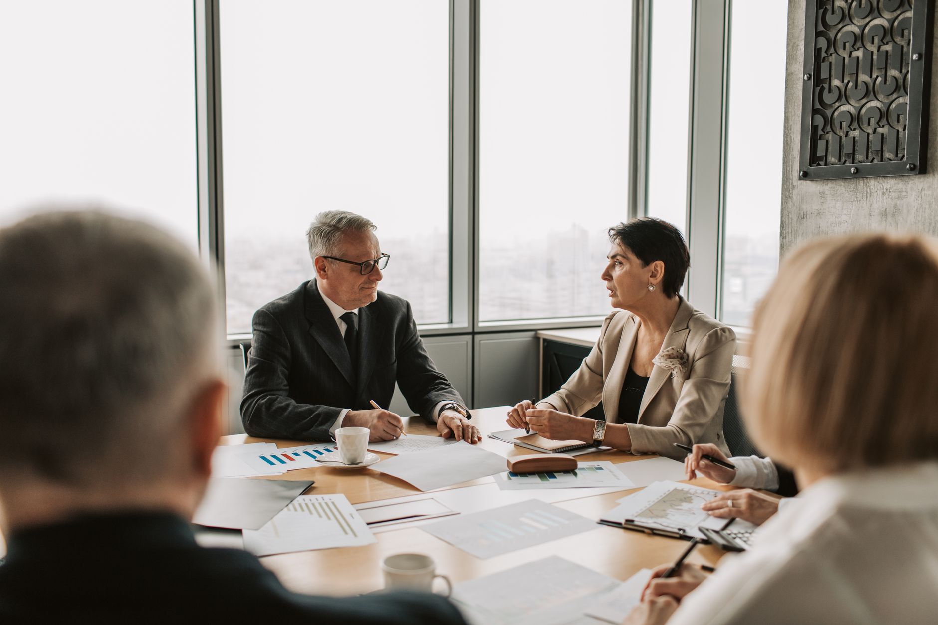 Business professionals in a boardroom negotiating terms of a corporate restructuring agreement