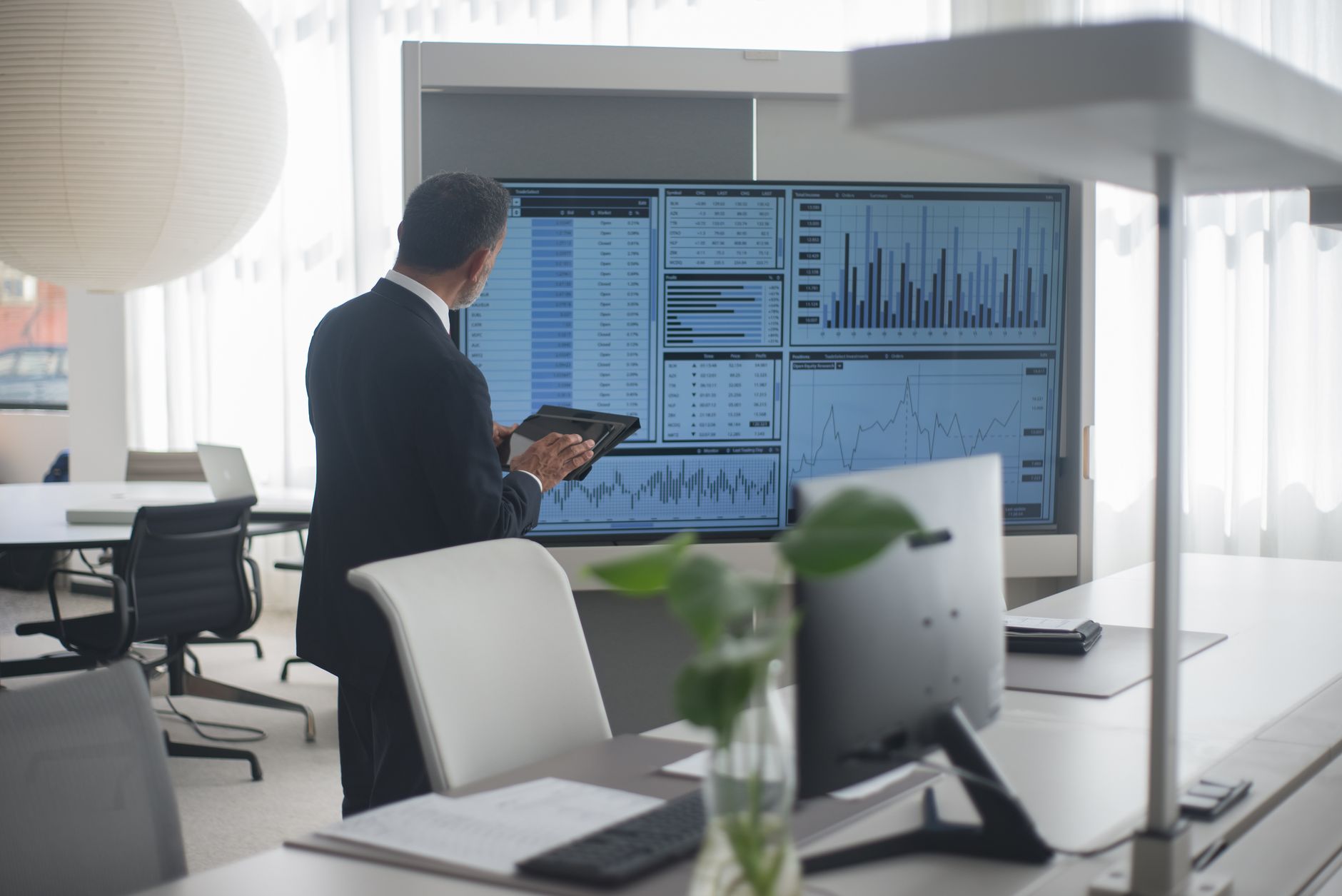 Empty institutional finance meeting room with charts and market data on display screens