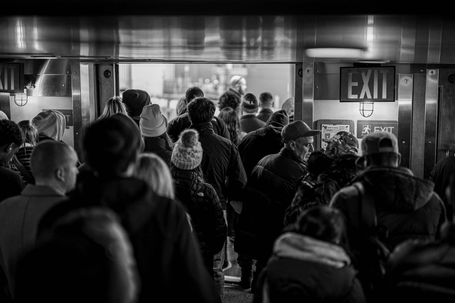 A crowded narrow exit doorway representing the concept of limited liquidity and forced selling pressure