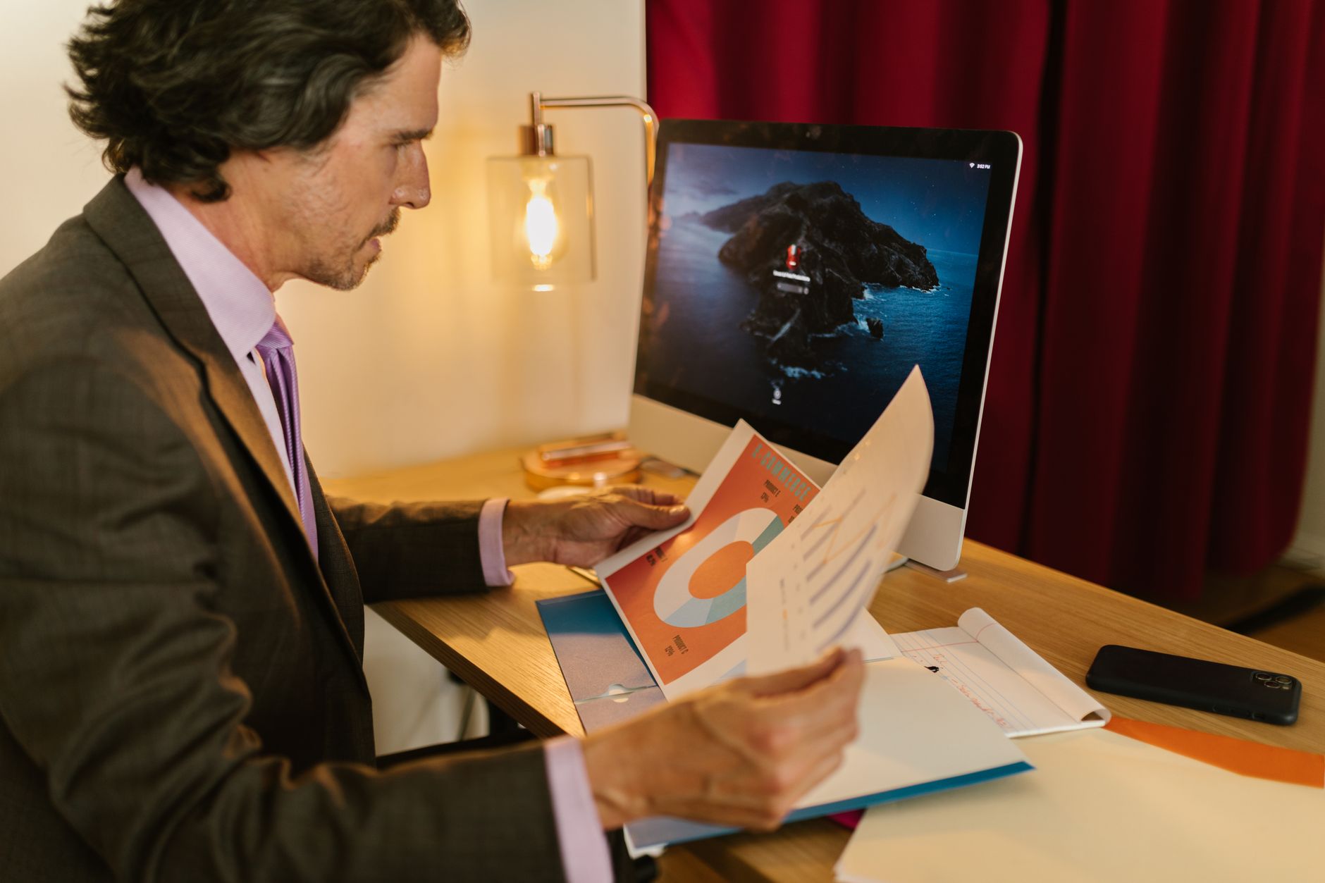 Investor reviewing financial data and portfolio analysis documents at a desk