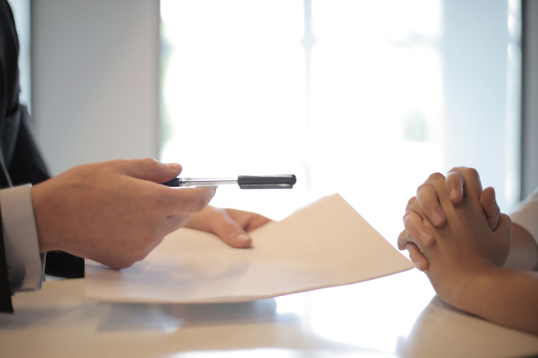 Two professionals reviewing and signing a financial loan document at a desk