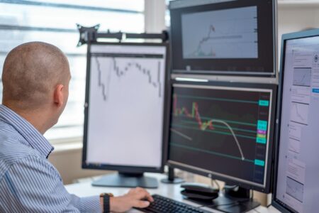 CLO Warehouse Financing Costs Are Quietly Squeezing New Issue Arbitrage Traders monitoring financial markets on multiple screens at a trading desk