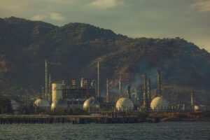 Industrial oil refinery with pipelines, representing energy price dynamics and inflation risk